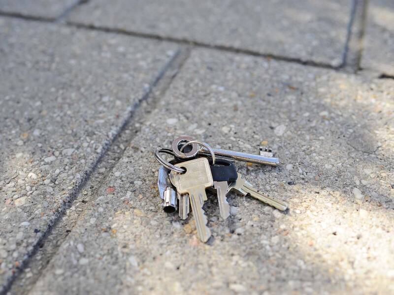 Ein verlorener Schlüsselbund liegt auf einem Steinboden.