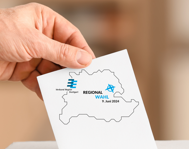 Eine Person wirft einen Stimmzettel zur Regionalwahl in eine Wahlurne.