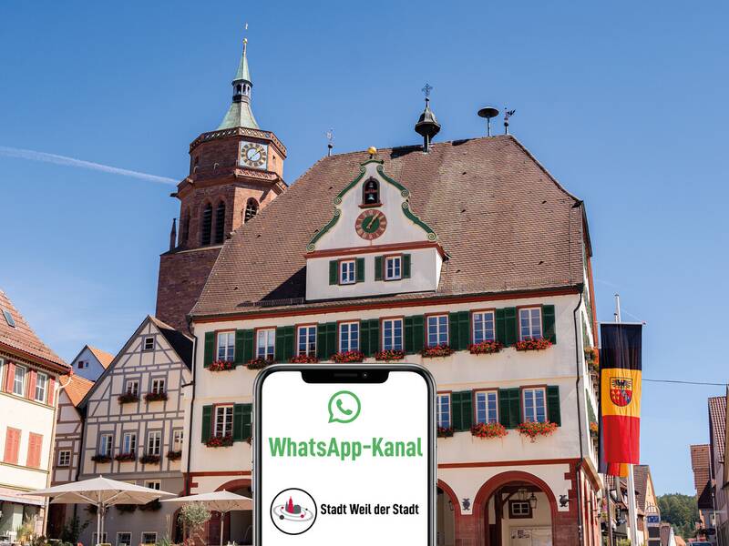 Ein Smartphone und der Schriftzug WhatsApp-Kanal Stadt Weil der Stadt im Vordergrund, im Hintergrund das Rathaus von Weil der Stadt.