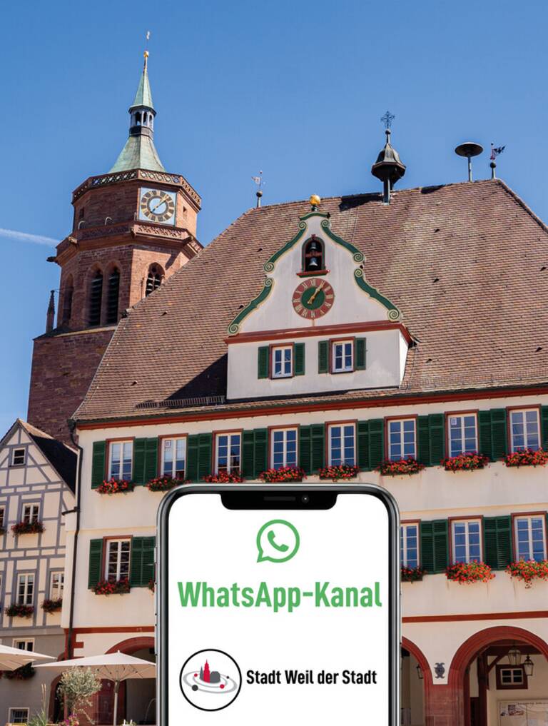 Ein Smartphone und der Schriftzug WhatsApp-Kanal Stadt Weil der Stadt im Vordergrund, im Hintergrund das Rathaus von Weil der Stadt.