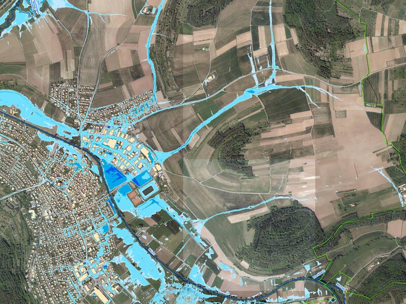 Das Luftbild von Merklingen - Weil der Stadt zeigt blaue Linien und Flächen, die mögliche Überschwemmungsgebiete markieren.