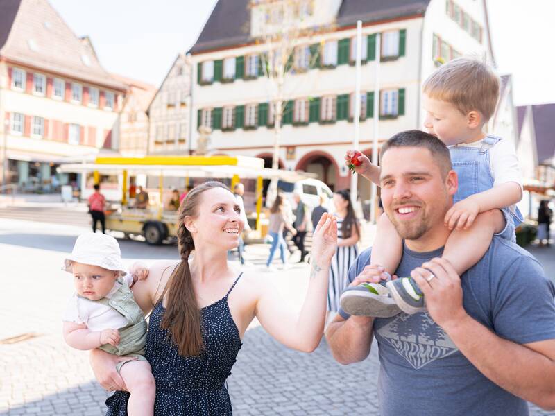 Eine Familie läuft über den Wochenmarkt.
