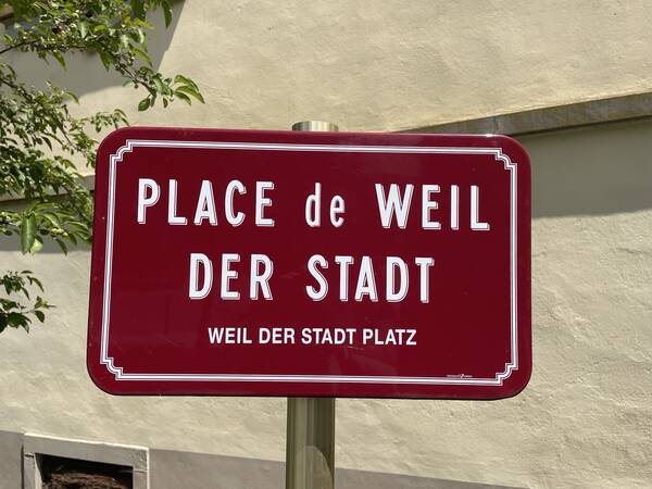 Ein Schild vom Weil der Stadt-Platz in Riquewihr.