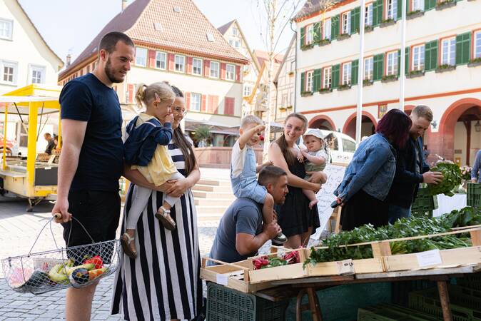 Familien stehen Schlange am Wochenmarktstand und genießen die Stimmung