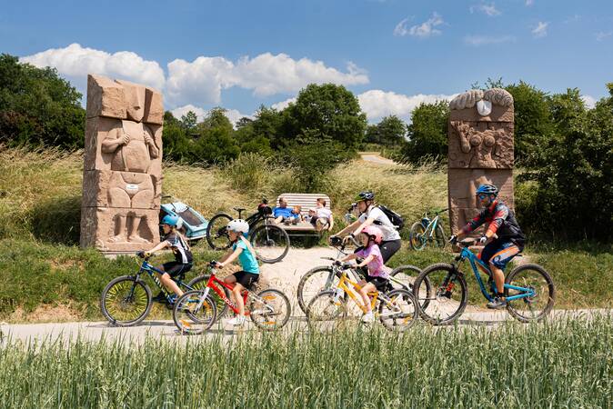 Fahrradfahrer vor einer Sculptur