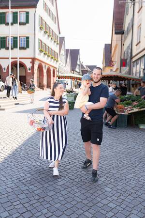 Eine Familie läuft über den Wochenmarkt.