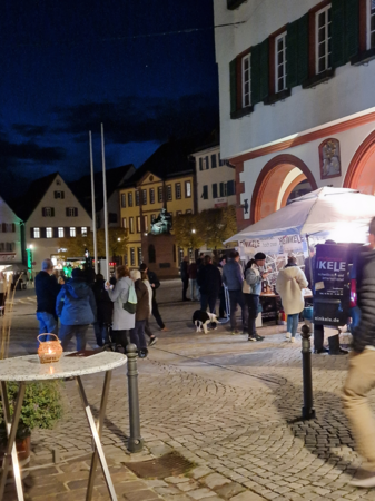Rathaus bei Nacht mit Essensverkauf davor und Menschentrauben