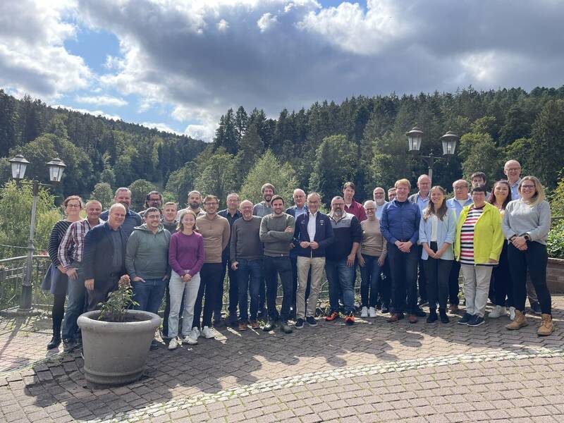 Die Mitglieder des Gemeinderates, die Verwaltungsspitze und die Amtsleiter stehen zusammen. Im Hintergrund ist Wald. 