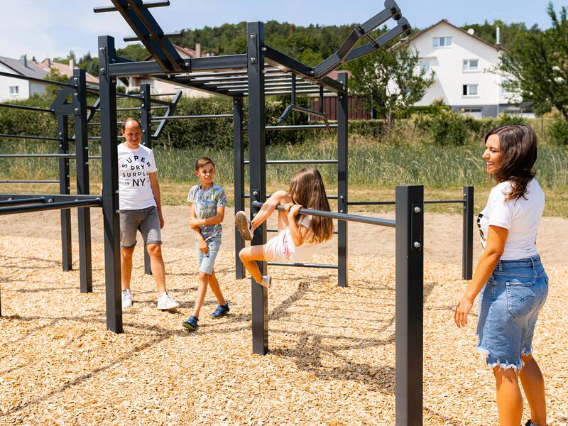 Eine Familie spielt auf einem Spielplatz.