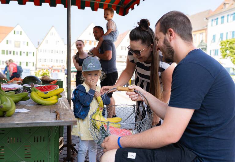 Familie kauft Obst auf dem Wochenmarkt.