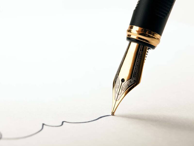 Ein eleganter Füller zeichnet eine Unterschrift auf Papier. 