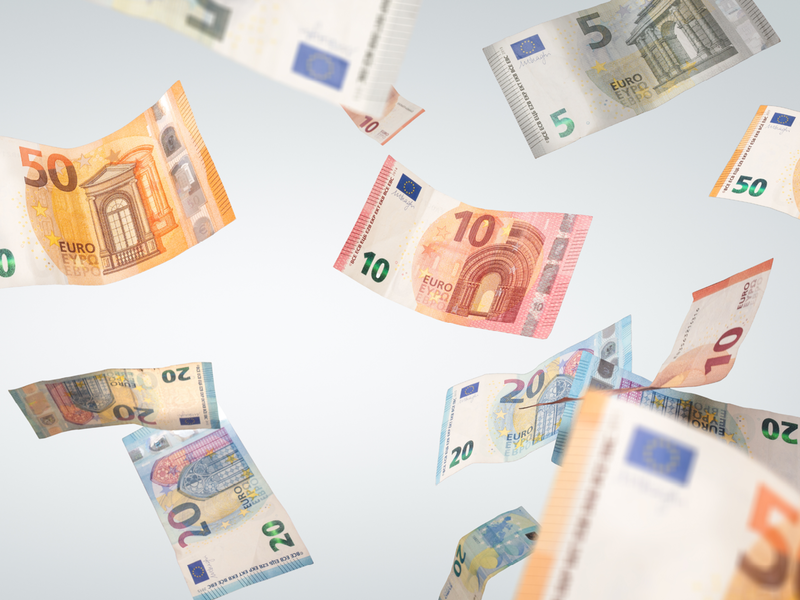Mehrere Euro-Geldscheine fliegen umher.