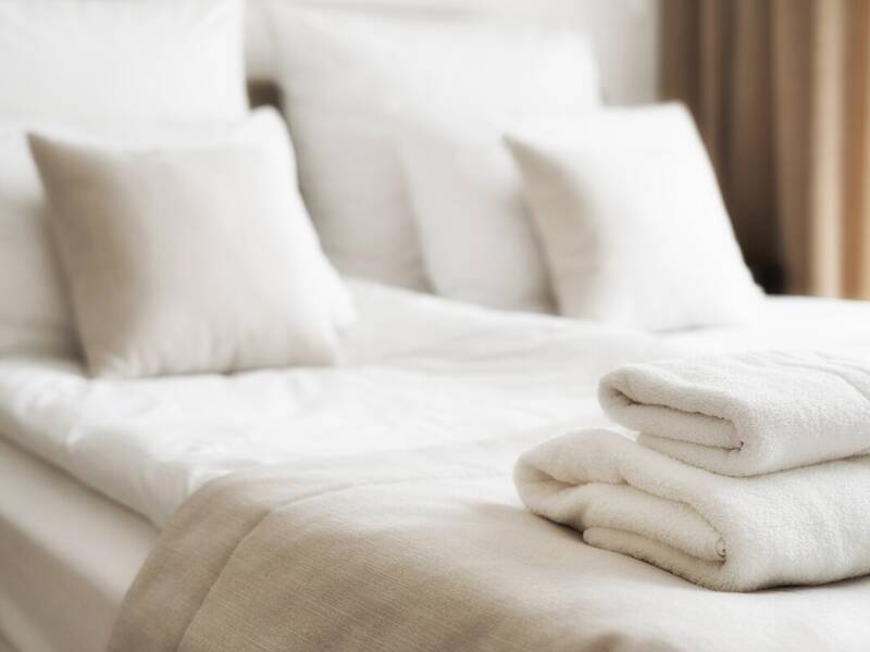 Ein Hotelbett mit Kissen und Handtüchern.