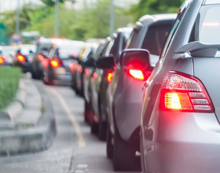 Viele Autos stehen im Stau. Ihre Bremslichter leuchten rot.