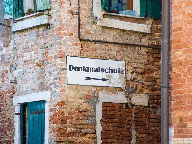 Ein Schild weist auf ein denkmalgeschütztes Gebäude hin.