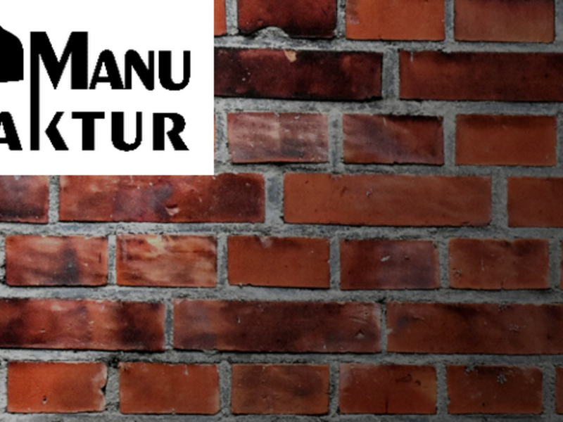 Das Logo der Manufaktur Weil der Stadt zeigt den Schriftzug „Manufaktur“ in klarer Schrift vor einer Mauer im Hintergrund, wodurch ein handwerklicher Eindruck entsteht.