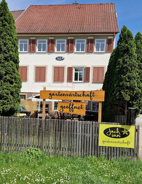 Der Außenbereich des Jack inn zeigt Sitzplätze im Freien vor dem Restaurant, an denen Gäste essen und trinken können.