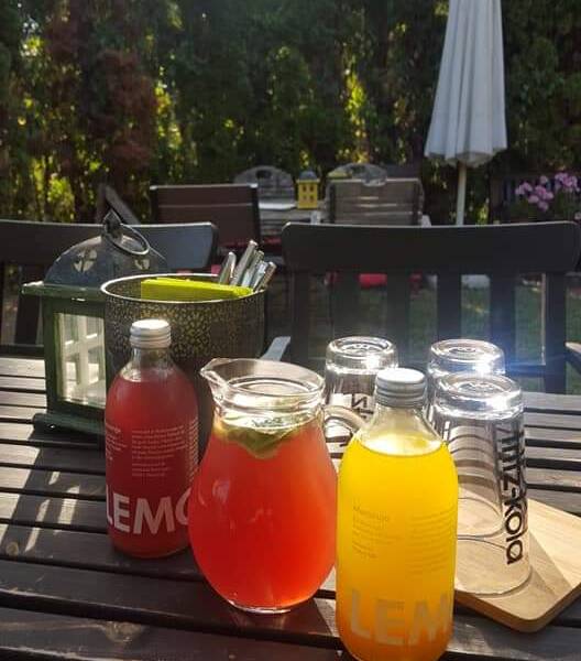 In einem Garten sind auf einem Tisch drei verschiedene Erfrischungsgetränke. 