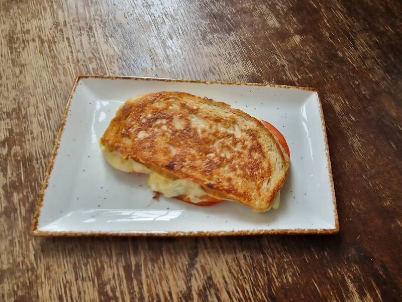 Auf der Platte ist ein Dinkel Käse Sandwich. 