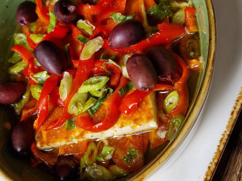 In der Schüssel befinden sich Feta, Oliven, Paprika und Chilischoten.